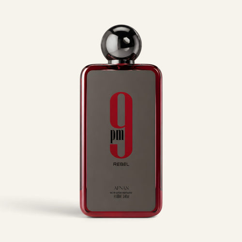 Profumo unisex 9PM Rebel di NOOR Arabian Essence in flacone rettangolare rosso con tappo sferico nero lucido